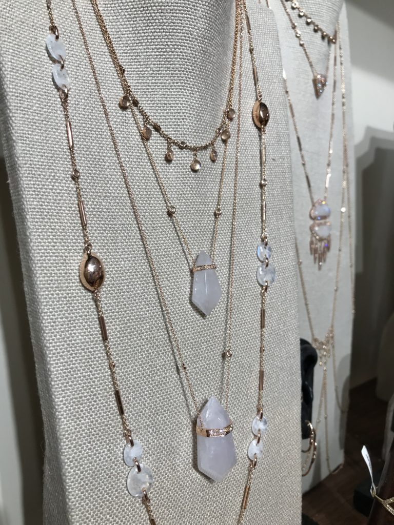 Layered Jacquie Aiche crystal necklaces on display at COUTURE