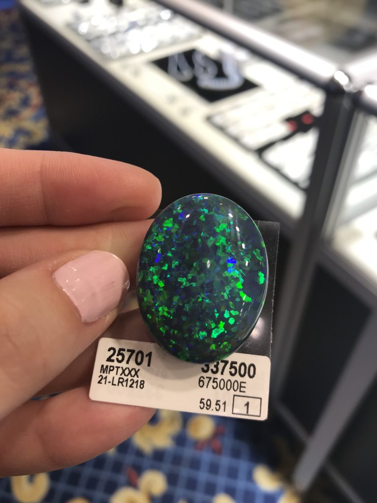 A 59.51 ct. black opal displaying flashes of blue and green